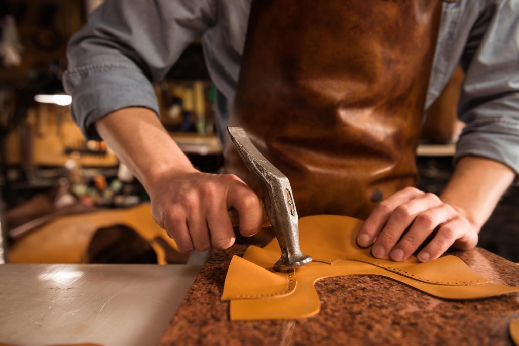 nahaufnahme-eines-schuster-der-mit-leder-arbeitet-min
